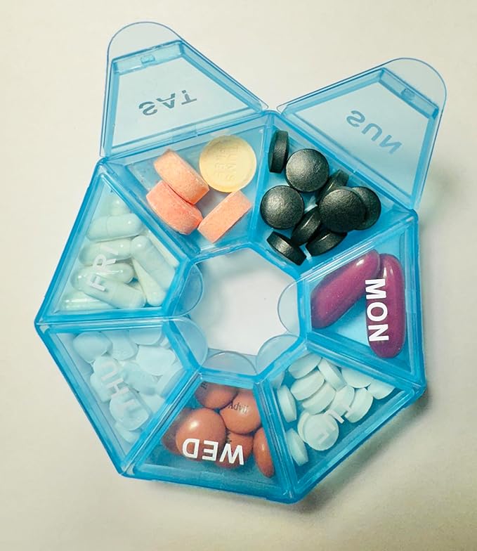 Blue pill organizer with assorted pills on a light background