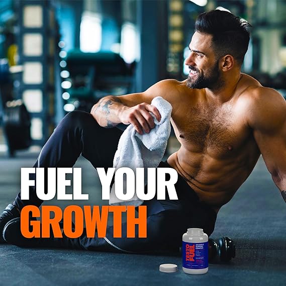 Muscular man sitting on a gym floor with 'Fuel Your Growth' text and supplement bottle.